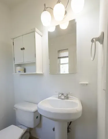a bathroom with a toilet sink and mirror