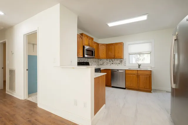 a kitchen with stainless steel appliances a refrigerator sink and stove
