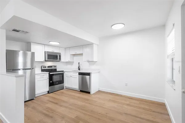 a kitchen with a refrigerator a stove top oven a sink and dishwasher