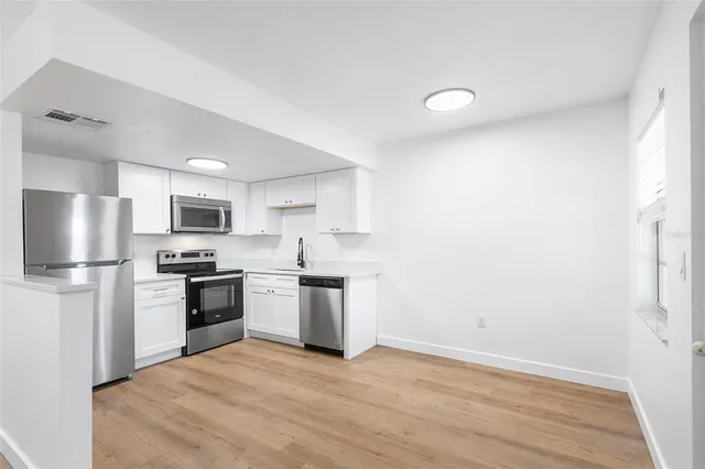 a kitchen with a refrigerator a stove top oven a sink and dishwasher