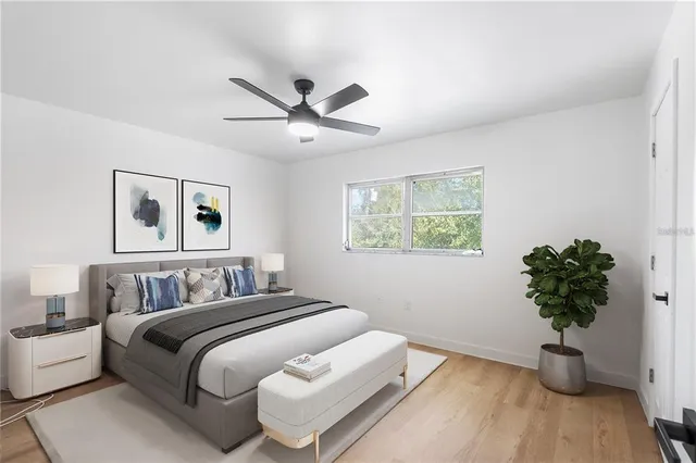 a bedroom with a large bed and a potted plant