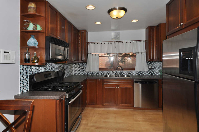 334 Stratford Road Des Plaines, IL 60016 - Photo 2 of 16 a kitchen with stainless steel appliances granite countertop a stove a sink and a microwave