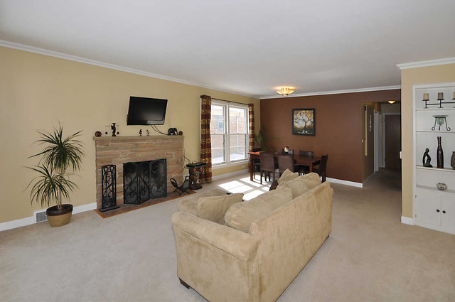 334 Stratford Road Des Plaines, IL 60016 - Photo 4 of 16 a living room with furniture a fireplace and a flat screen tv