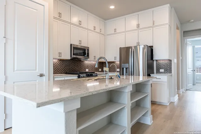 a kitchen with refrigerator and cabinets