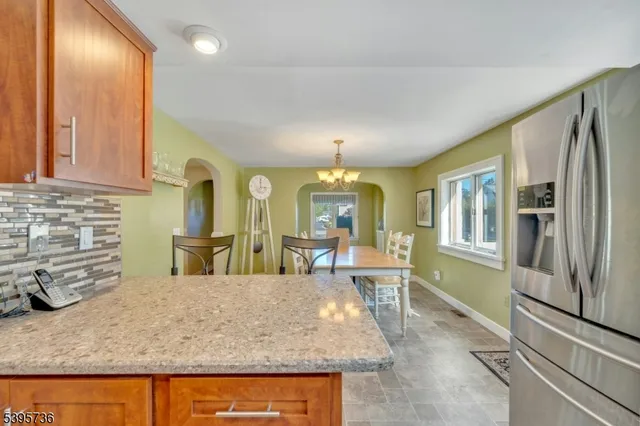 a large kitchen with granite countertop a sink and dishwasher a stove with wooden cabinets