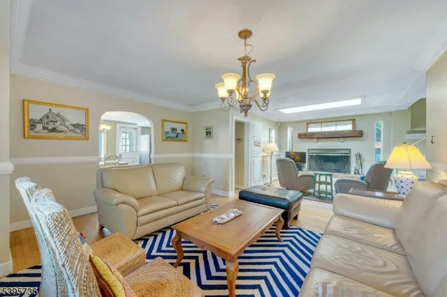 a living room with furniture a dining table and a chandelier