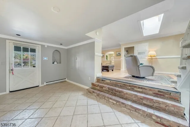 a living room with furniture a chandelier and a dining table