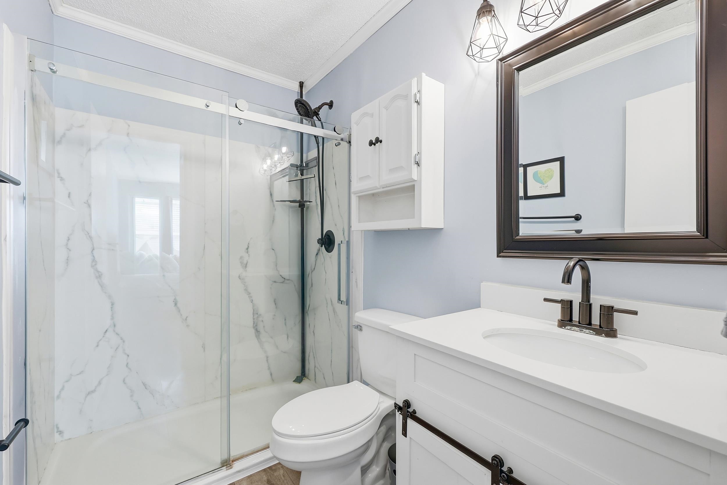 2001 Spring Street, Unit H2 North Myrtle Beach, SC 29582 - Photo 14 of 25 Bathroom with ornamental molding, vanity, a marble finish shower, and a textured ceiling