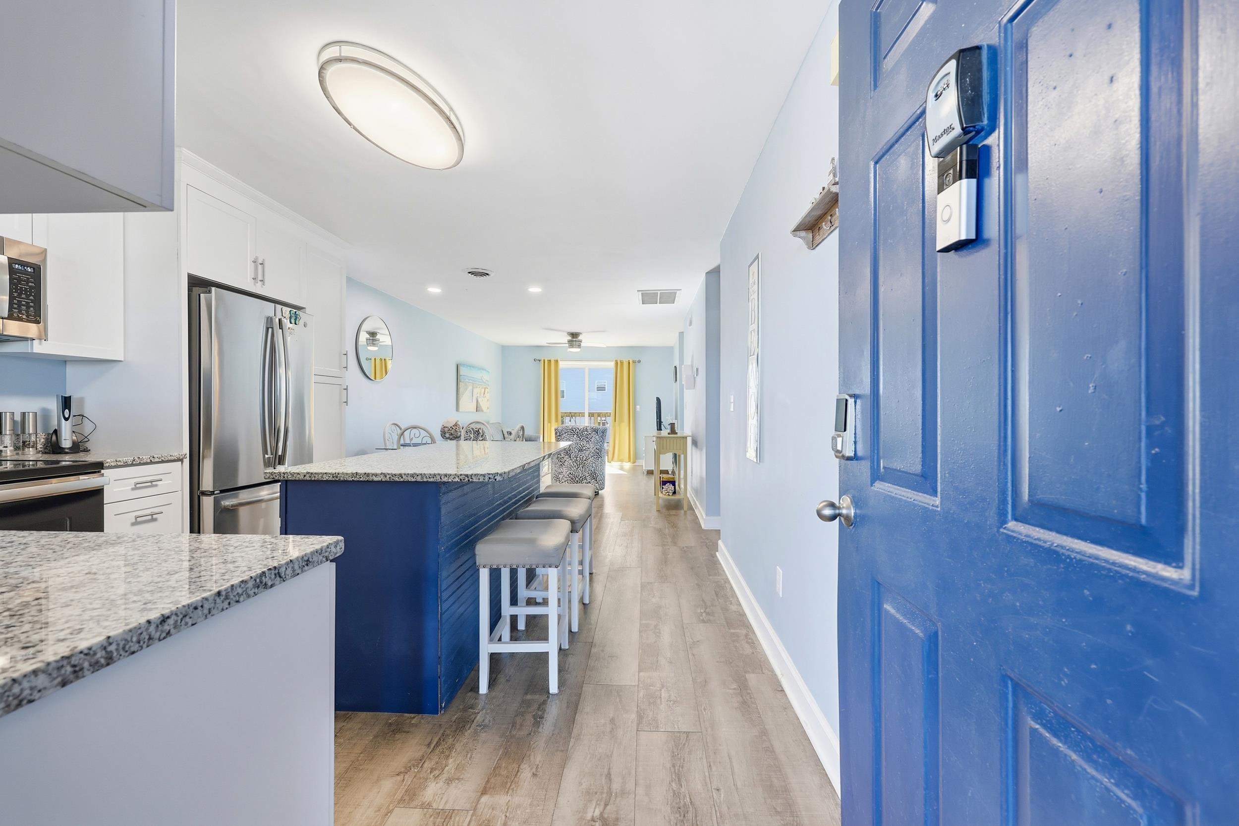 2001 Spring Street, Unit H2 North Myrtle Beach, SC 29582 - Photo 3 of 25 Kitchen with white cabinetry, a kitchen island, a kitchen breakfast bar, light stone countertops, and stainless steel appliances