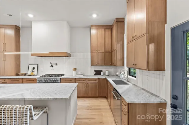 a kitchen with stainless steel appliances granite countertop a sink and a refrigerator