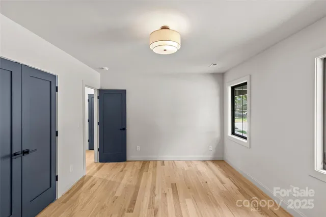 an empty room with windows and closet