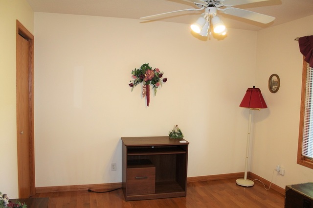 15539 Henry Road, Unit A Morrison, IL 61270 - Photo 3 of 32 a view of a room with a potted plant wooden floor and fan