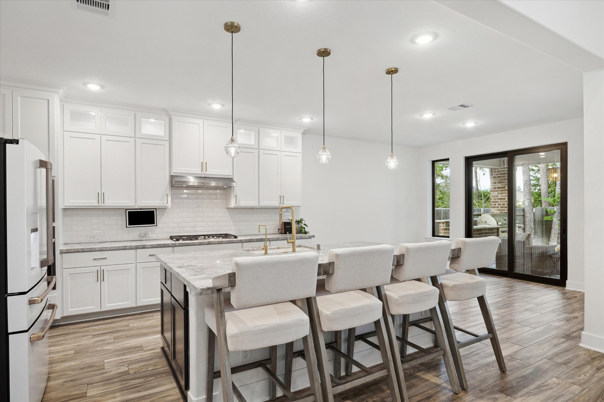 17355 Camillia Trail Conroe, TX 77302 - Photo 7 of 34 a view of a kitchen with kitchen island granite countertop lots of white cabinets appliances and furniture
