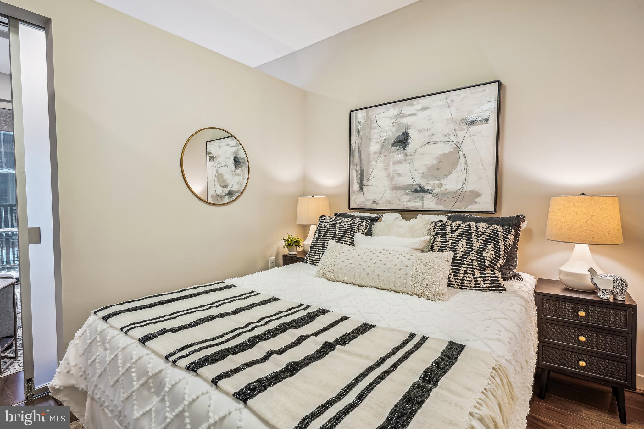 1320 Fenwick Lane, Unit 507 Silver Spring, MD 20910 - Photo 13 of 46 a bedroom with a bed and a lamp on dresser