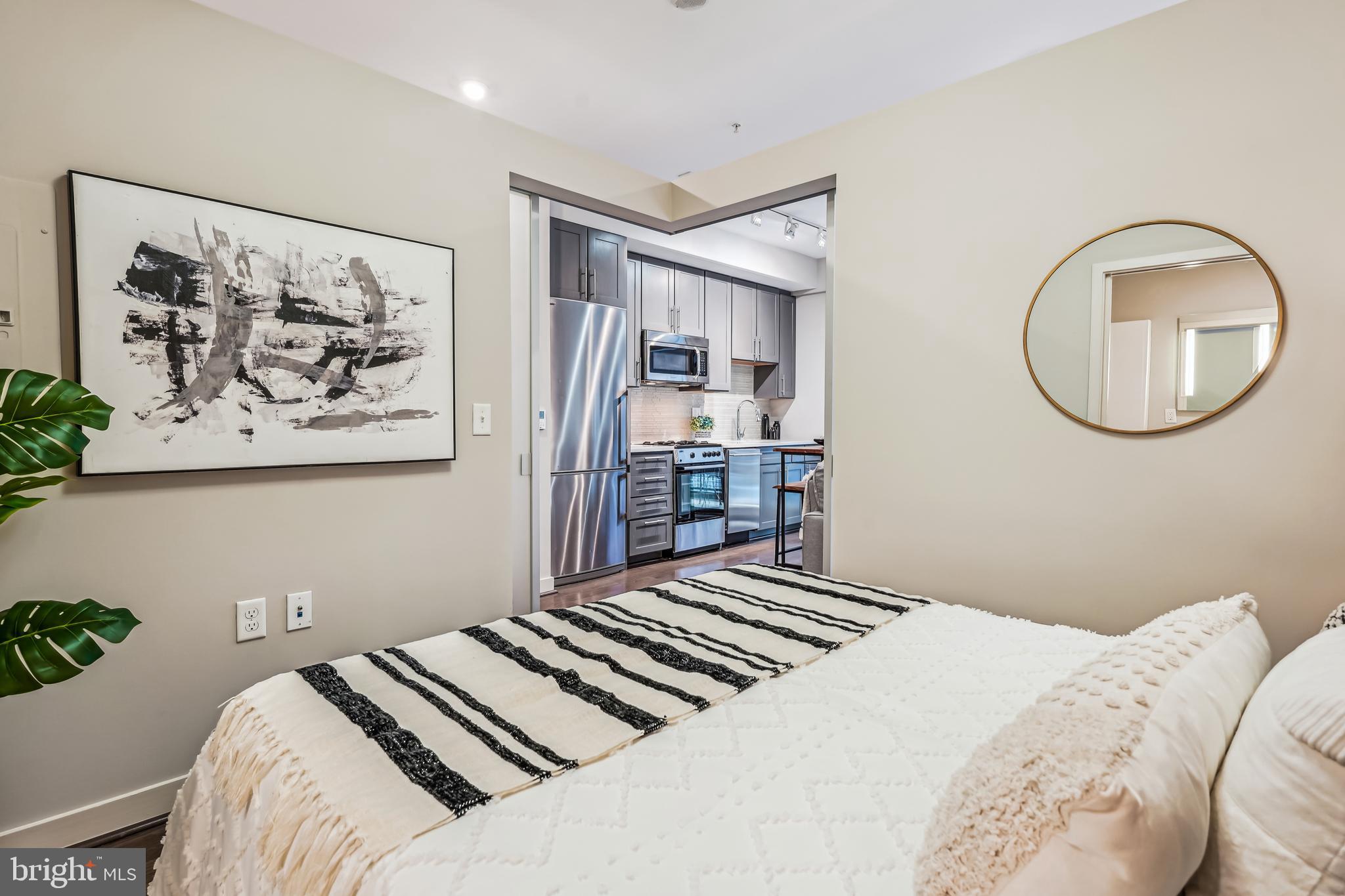 1320 Fenwick Lane, Unit 507 Silver Spring, MD 20910 - Photo 14 of 46 a bedroom with a large bed and a chandelier