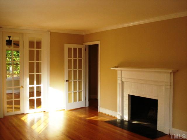 3038 Lewis Farm Road Raleigh, NC 27607 - Photo 4 of 12 a view of empty room with a fireplace and wooden floor