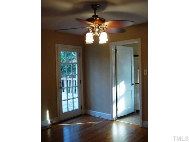 3038 Lewis Farm Road Raleigh, NC 27607 - Photo 9 of 12 a view of an empty room with wooden floor and a window