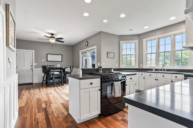 a kitchen with stainless steel appliances granite countertop a stove and a wooden floors