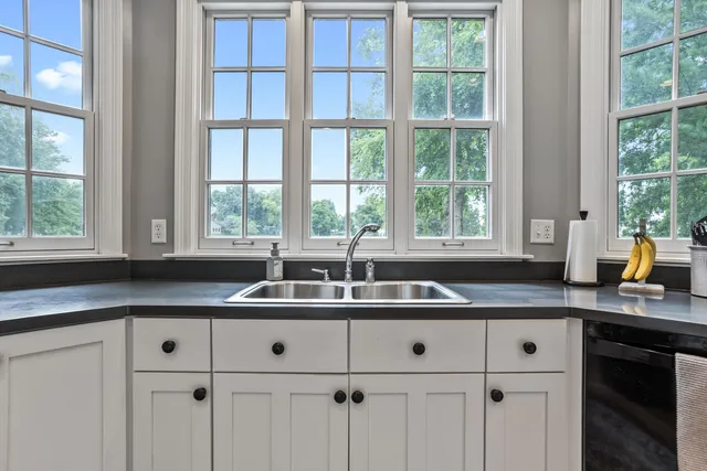 a kitchen with granite countertop a sink and white cabinets