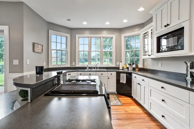 a kitchen with granite countertop a stove a sink and a granite counter top