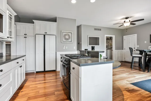 a kitchen with cabinets and wooden floor
