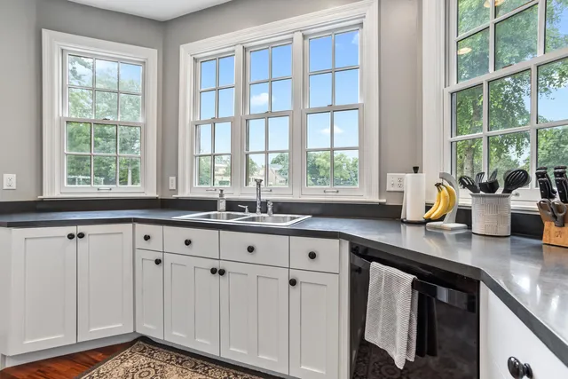 a kitchen with stainless steel appliances white cabinets and a large window
