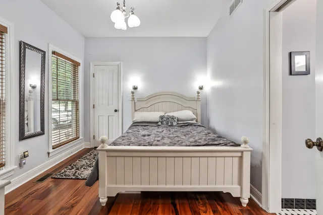a bedroom with a bed a window and dresser