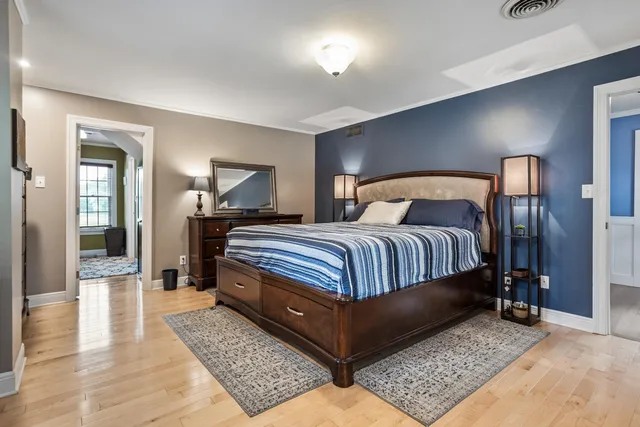 a bedroom with a bed a mirror and lamp