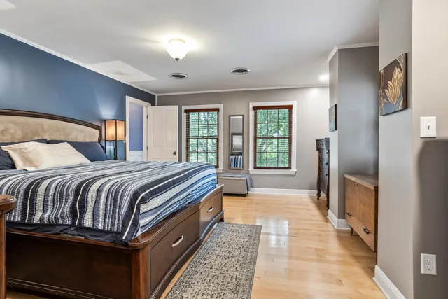 a large bedroom with a bed and wooden floor
