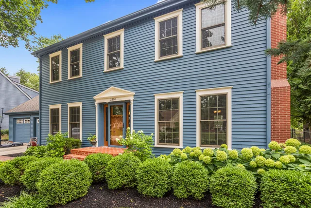 a view of a brick house with a large window and flower plants