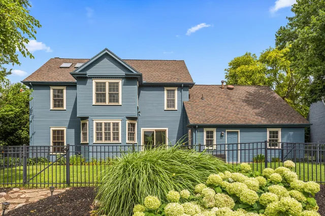 a view of a house with a small yard plants and large tree