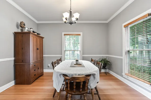 a dining room with furniture a chandelier and wooden floor