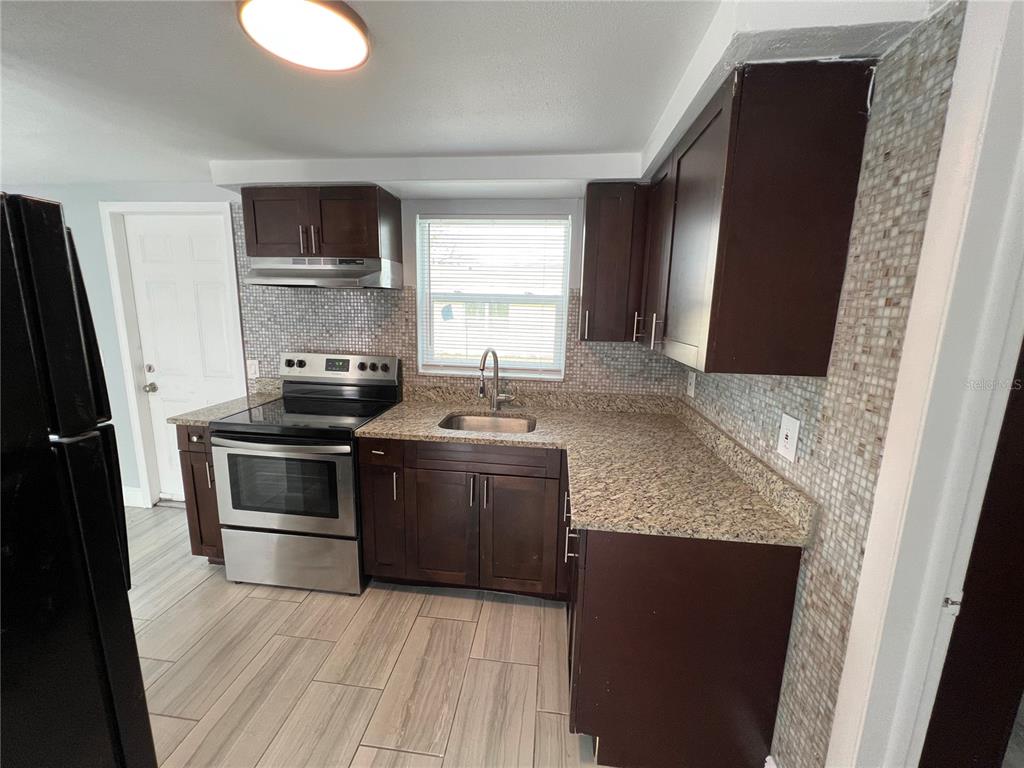 5333 Pasadena Drive, Unit 5333 New Port Richey, FL 34652 - Photo 5 of 12 a kitchen with a sink and a stove top oven