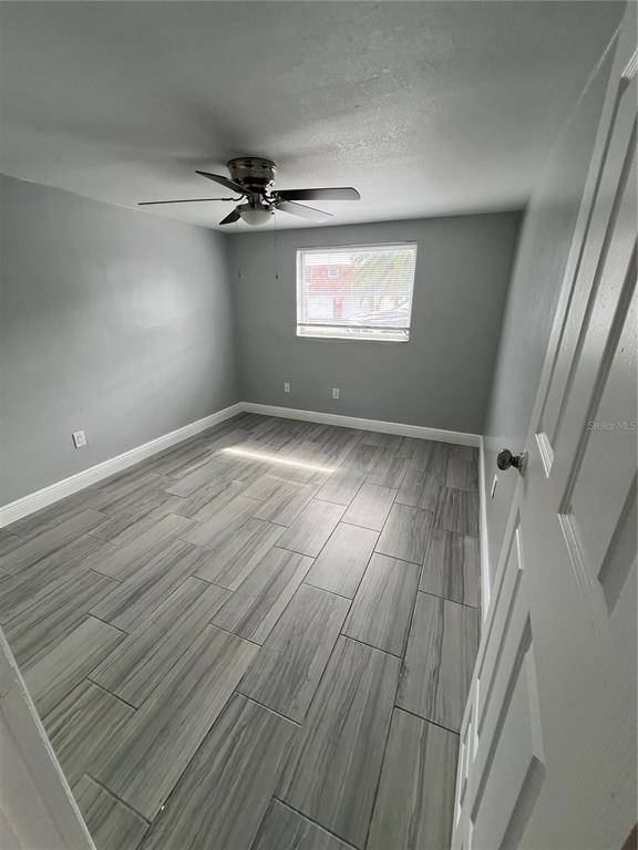 5333 Pasadena Drive, Unit 5333 New Port Richey, FL 34652 - Photo 8 of 12 an empty room with windows and fan