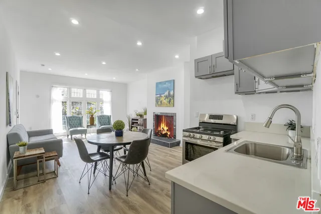 a kitchen with stainless steel appliances a table and chairs in it
