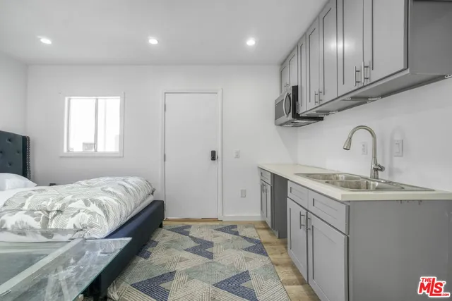 a bedroom with a sink and a refrigerator