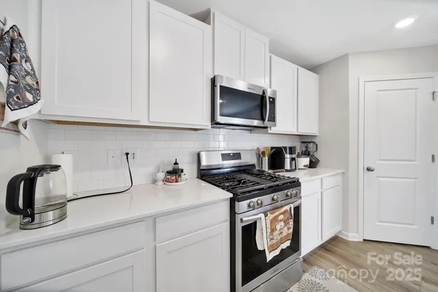 a kitchen with granite countertop a sink a stove and cabinets