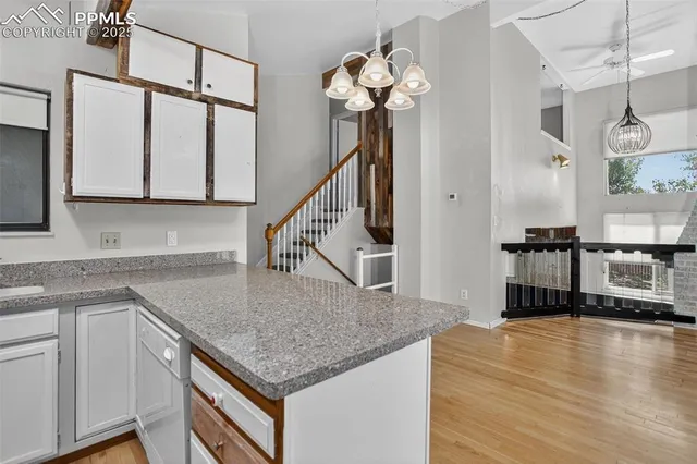 a kitchen with stainless steel appliances granite countertop a sink a oven and a wooden floor