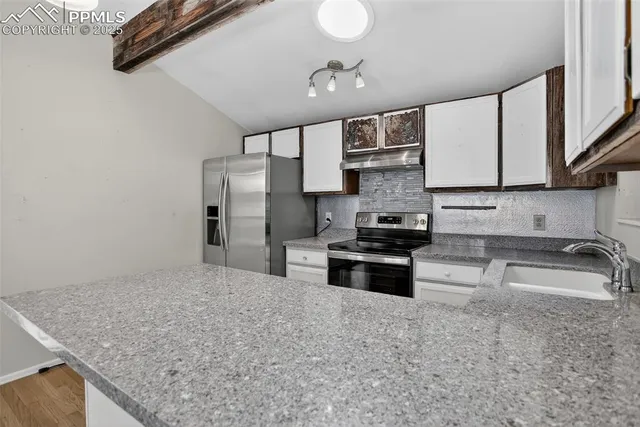 a kitchen with stainless steel appliances granite countertop a sink stove and refrigerator