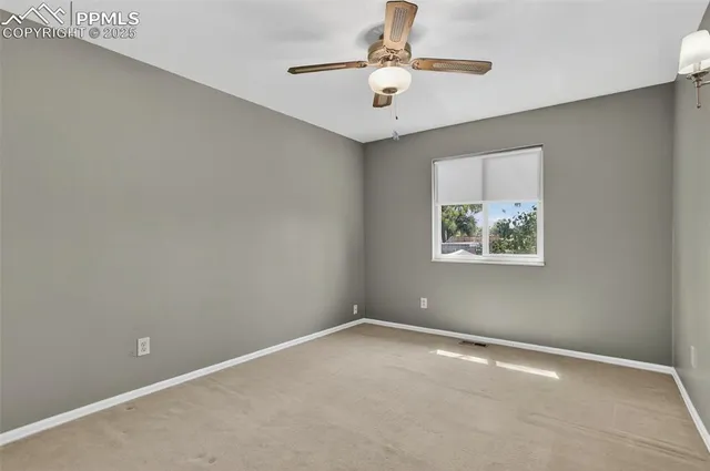 an empty room with windows and ceiling fan