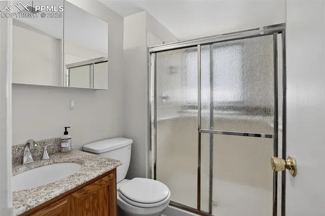 a bathroom with a granite countertop sink toilet and shower