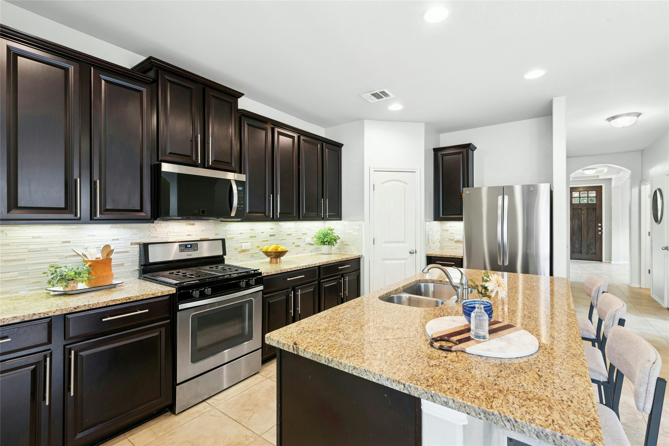 390 Fletcher Bend Buda, TX 78610 - Photo 3 of 36 a kitchen with granite countertop stainless steel appliances and wooden cabinets
