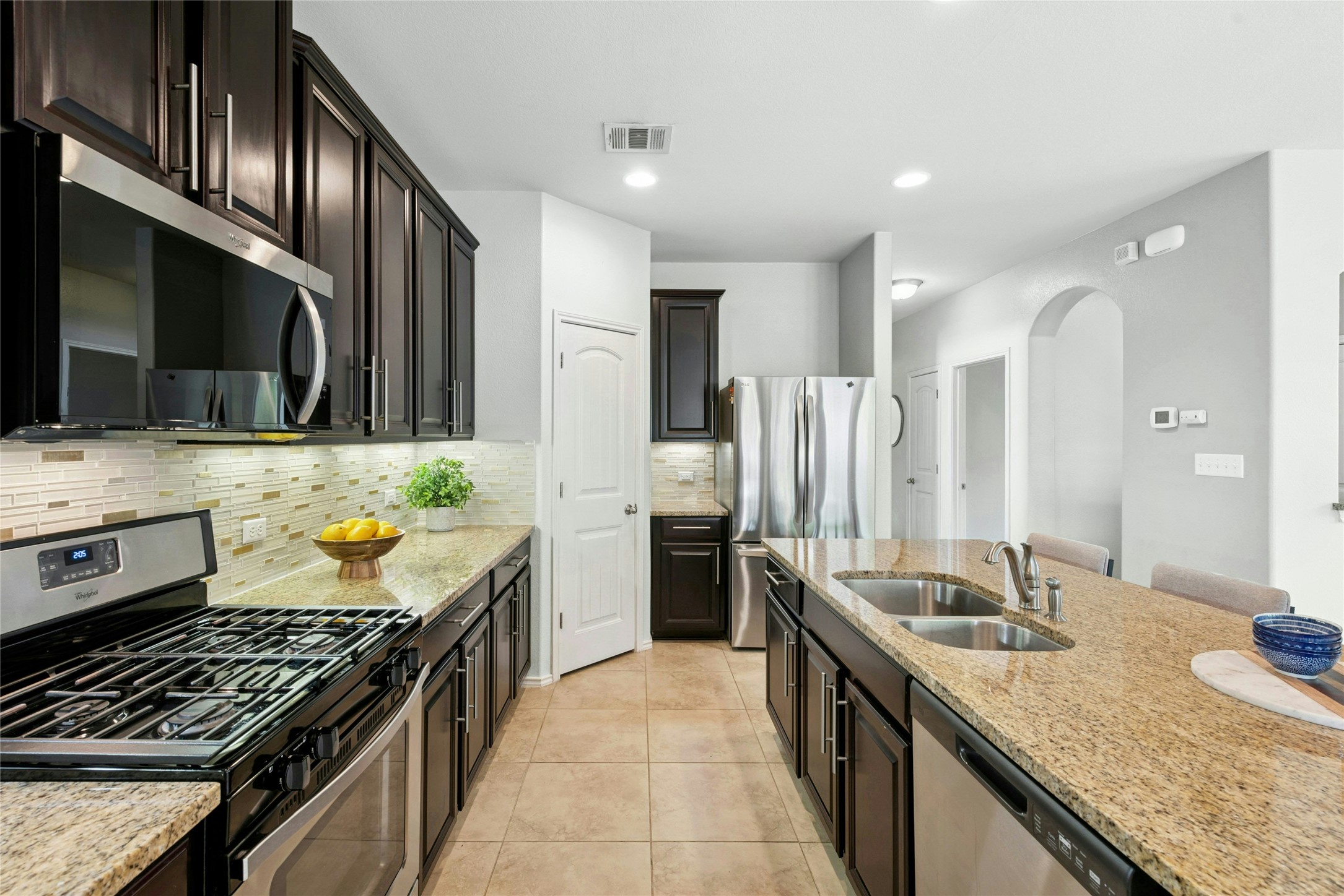 390 Fletcher Bend Buda, TX 78610 - Photo 4 of 36 a kitchen with stainless steel appliances granite countertop a sink stove and refrigerator