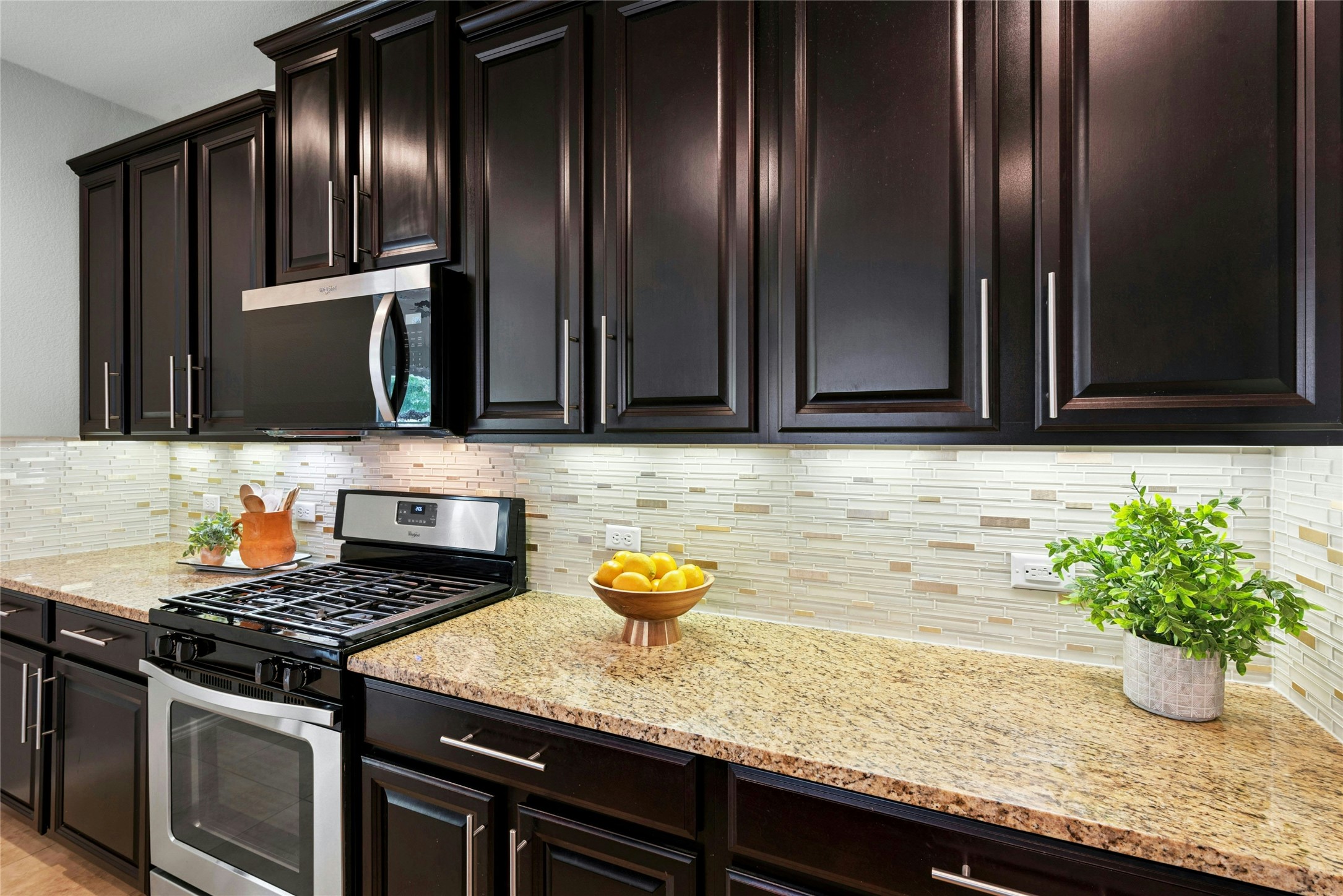 390 Fletcher Bend Buda, TX 78610 - Photo 5 of 36 a kitchen with granite countertop stainless steel appliances and wooden cabinets