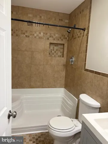 a white toilet sitting next to a bath tub and a shower