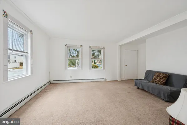 a view of an empty room with window and a couch