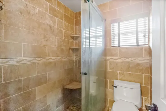 a bathroom with a toilet and a shower
