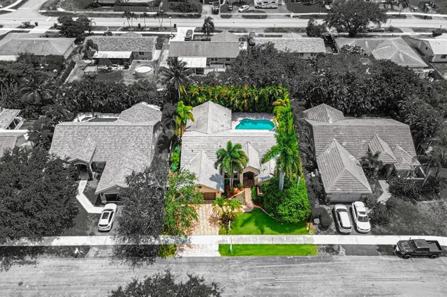 an aerial view of a house with a yard and houses