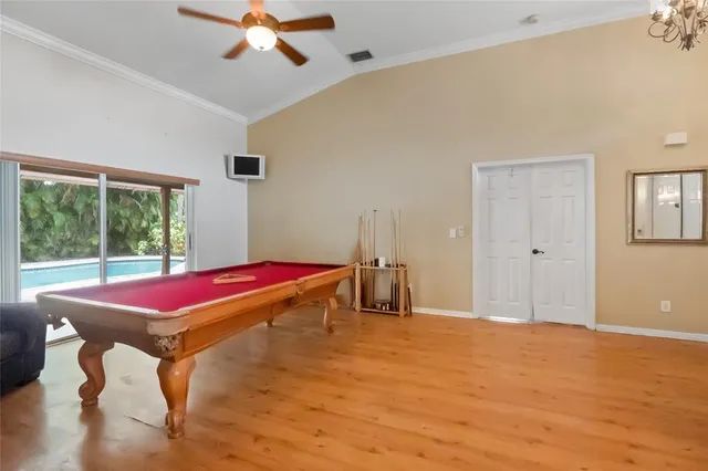 a living room with a table and a ceiling fan