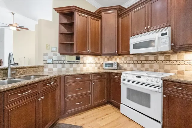 a kitchen with stainless steel appliances granite countertop a sink stove and cabinets